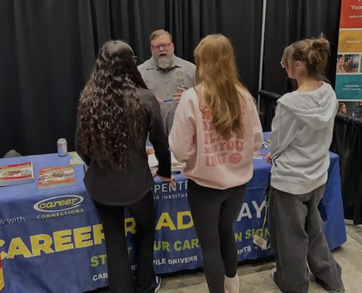 students talking to an adult at a career booth