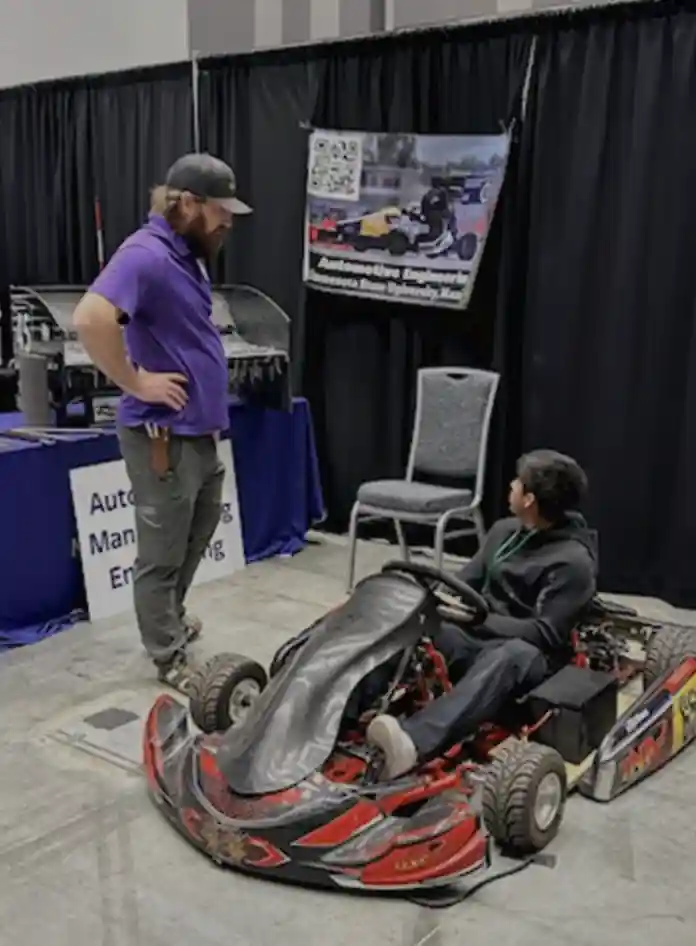 Students at a career booth looking at a robot