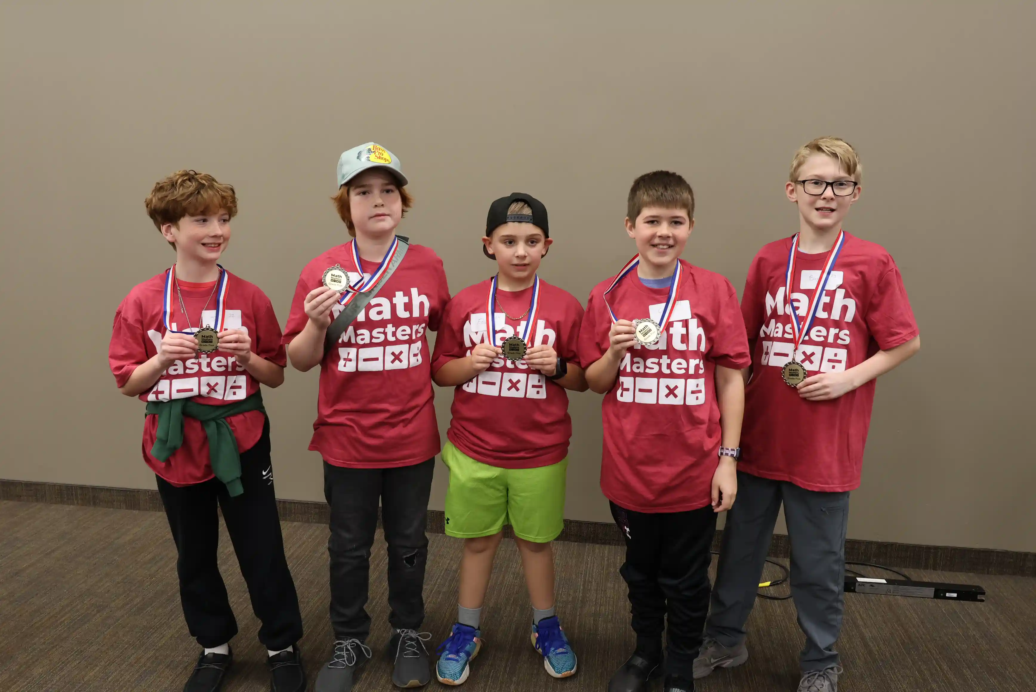 5 students standing together wearing their medals.