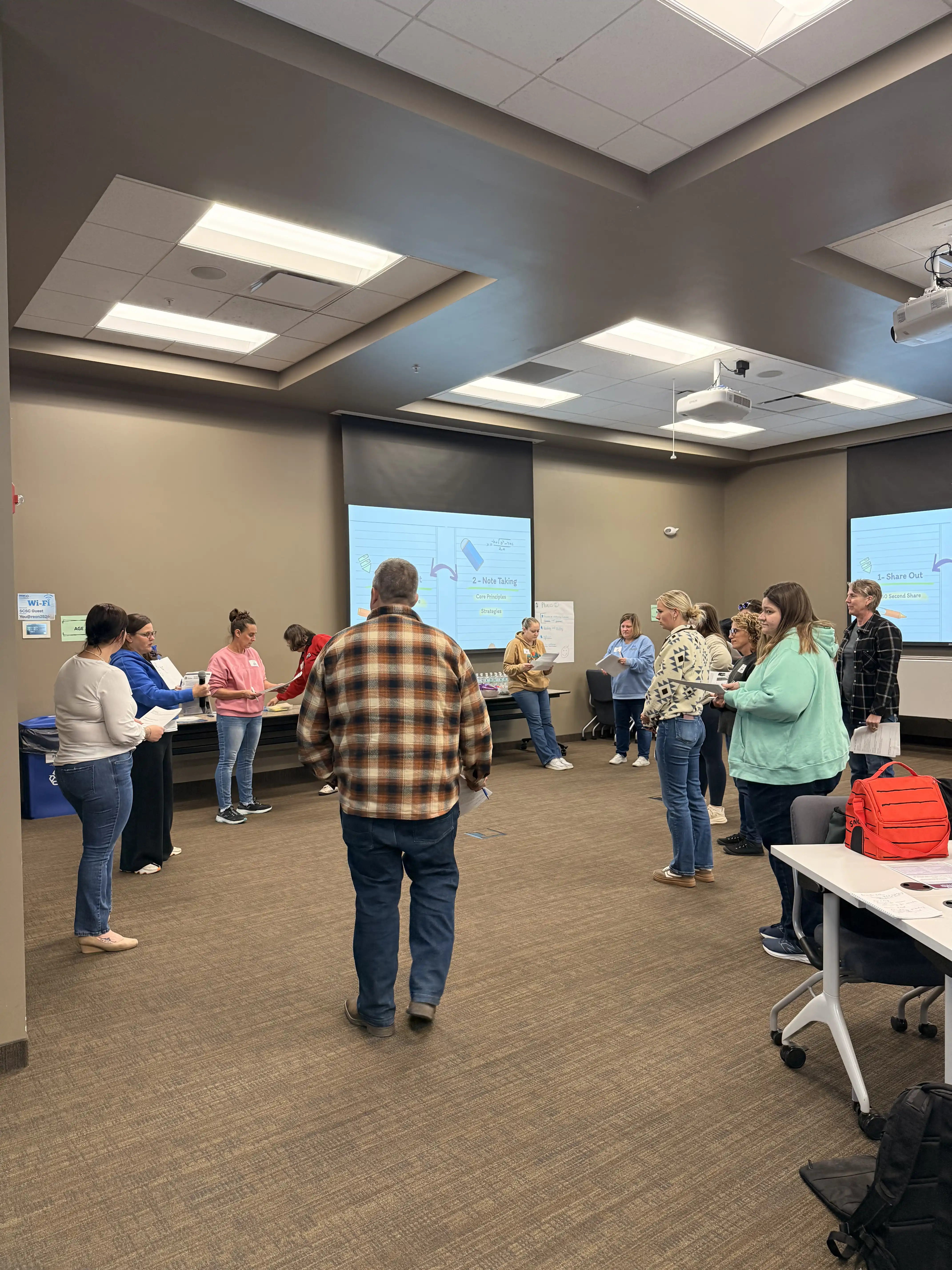 Students standing in a conference room talking to each other in a session