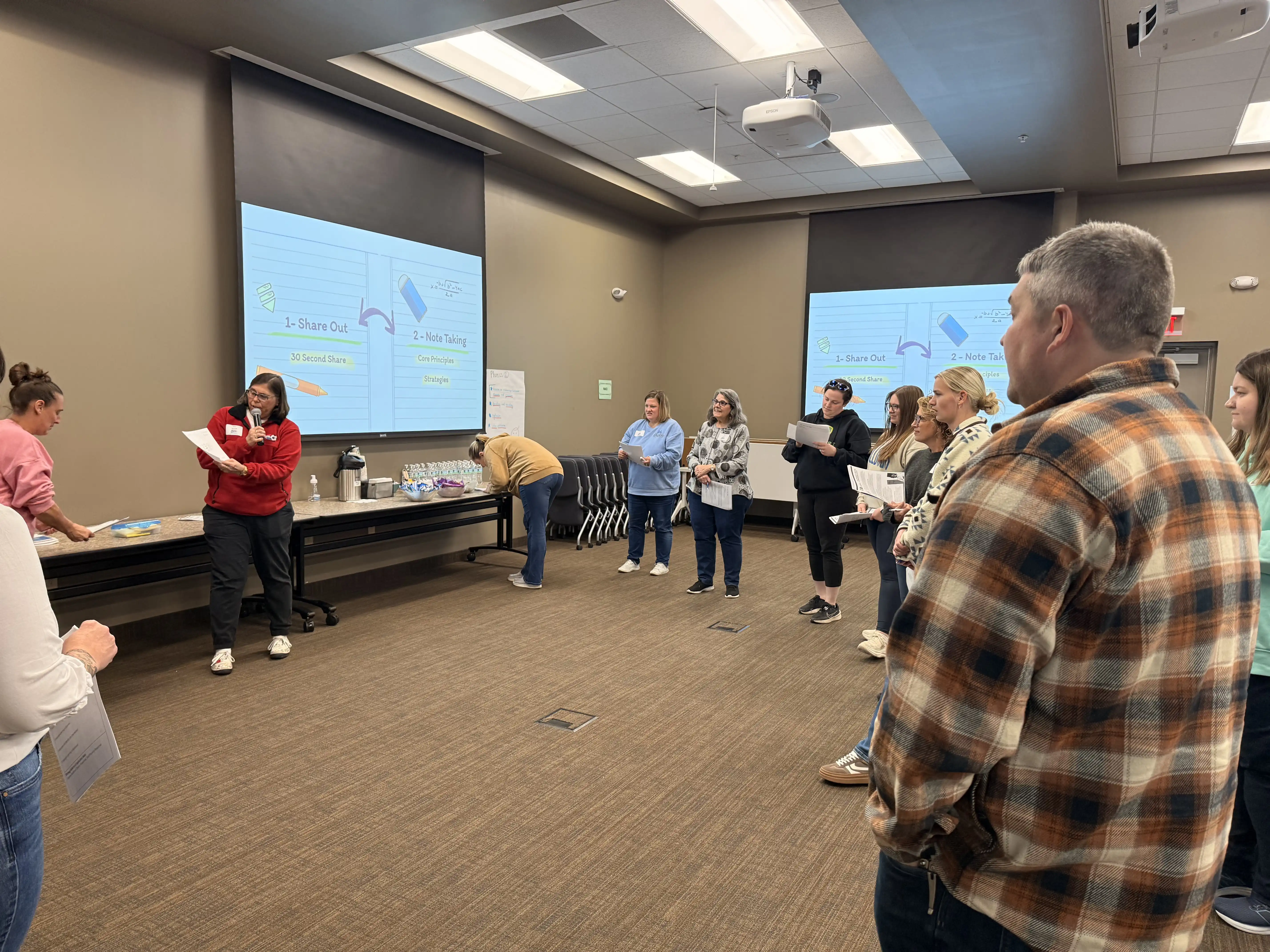 Teachers standing in a circle during a professional development session