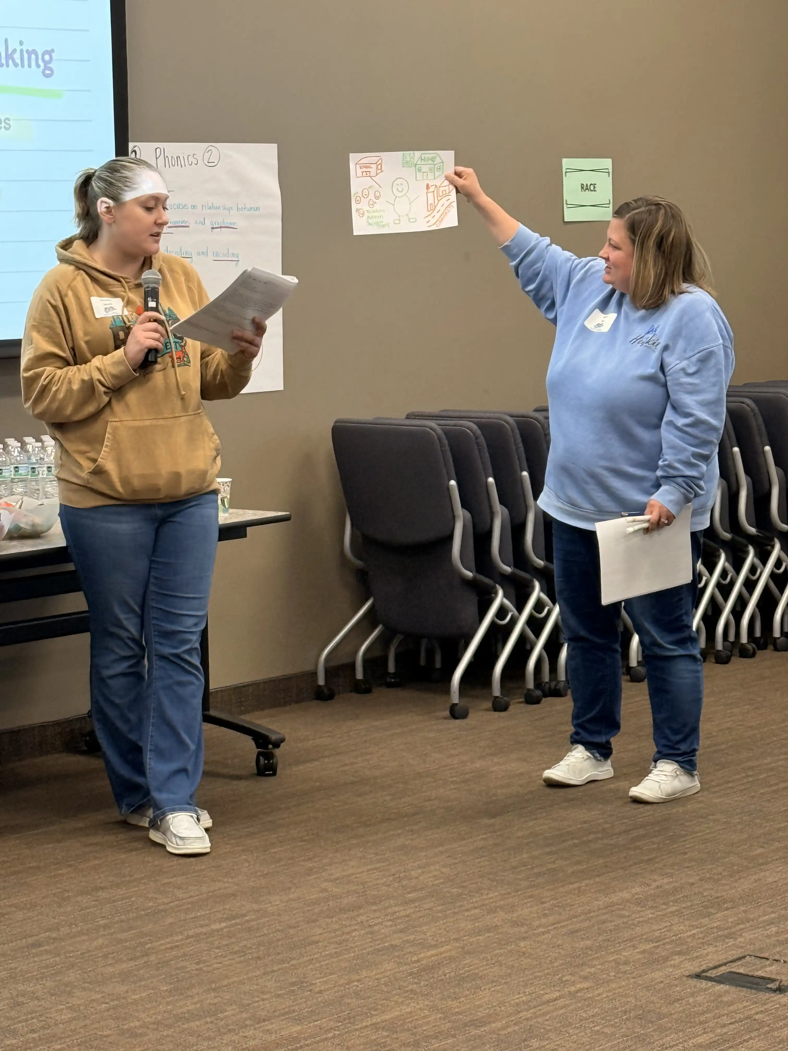 2 individuals standing up front presenting
