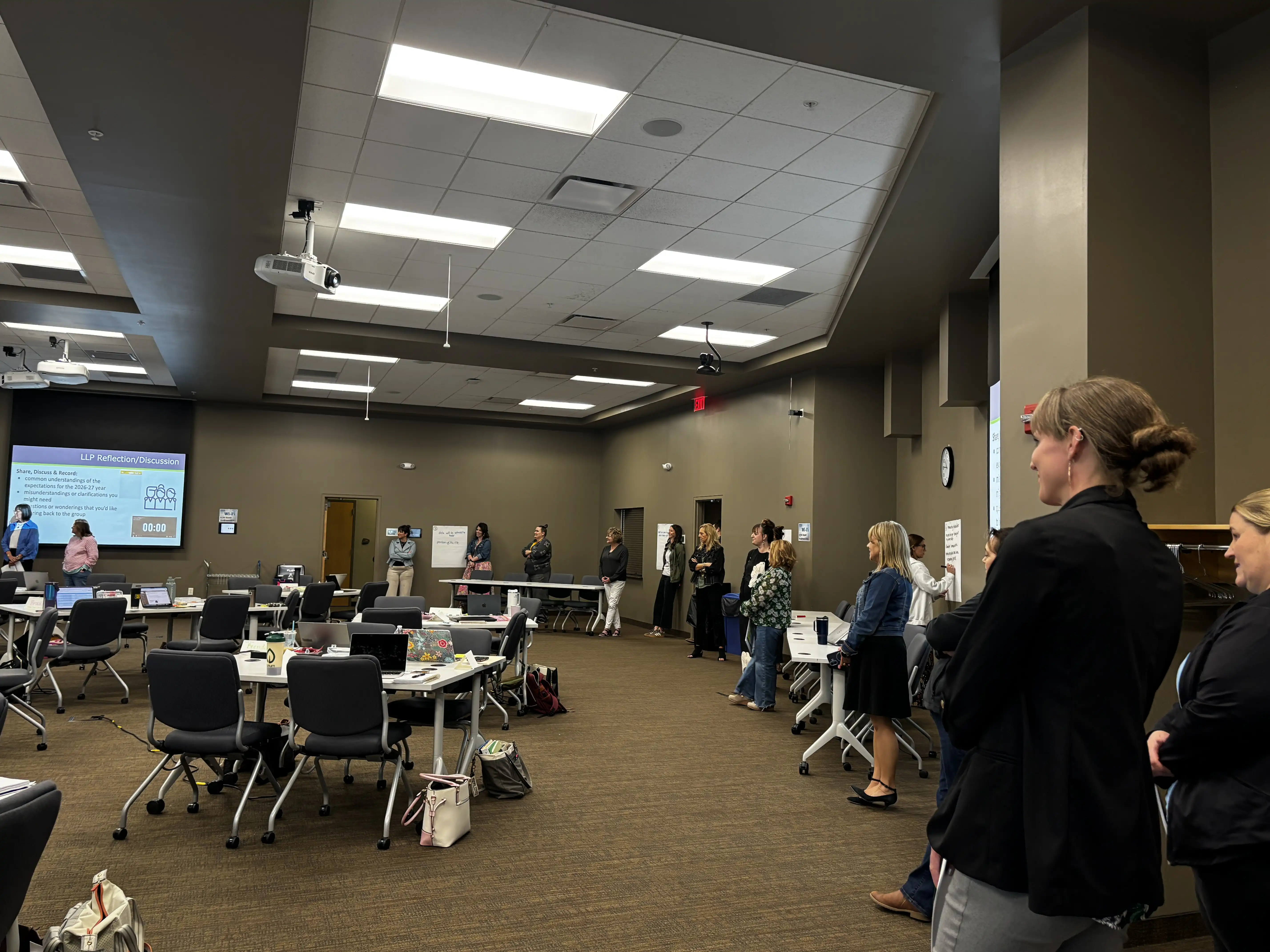 Teachers standing in a circle around the room