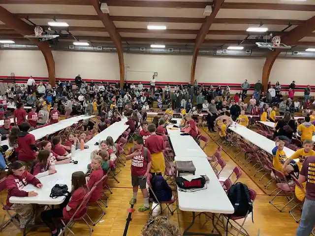 students sitting by tables listening to instructions.