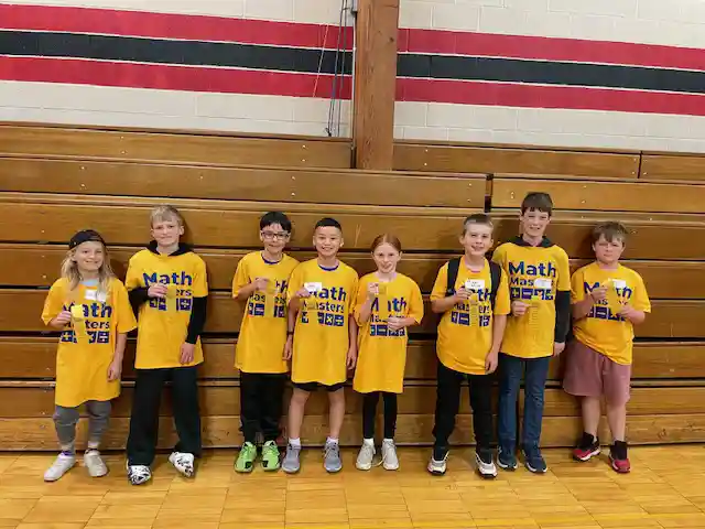 Students standing holding their medals
