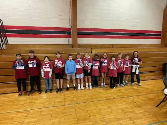 Students standing holding their medals