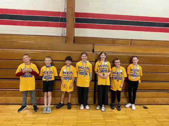 Students standing holding their medals