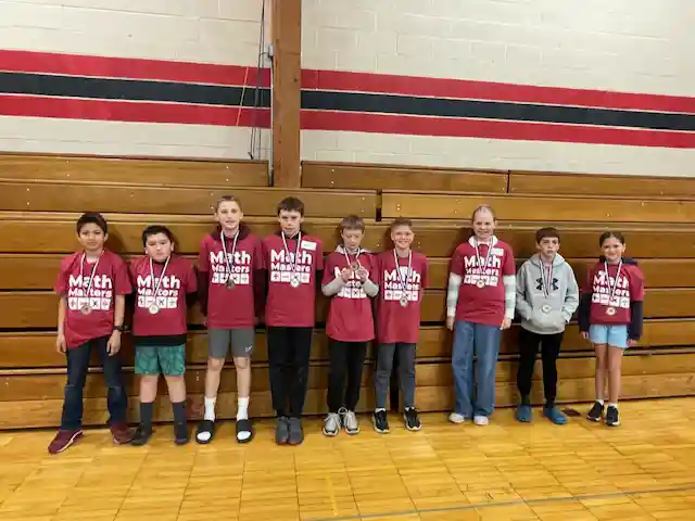 Students standing holding their medals