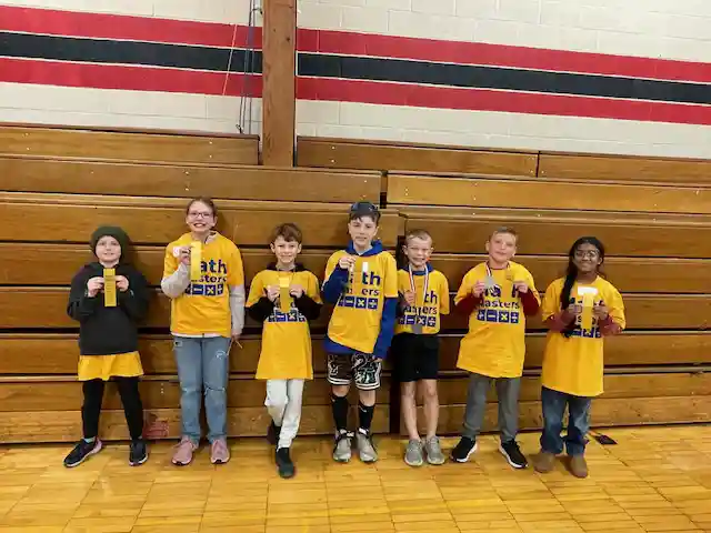 Students standing holding their medals