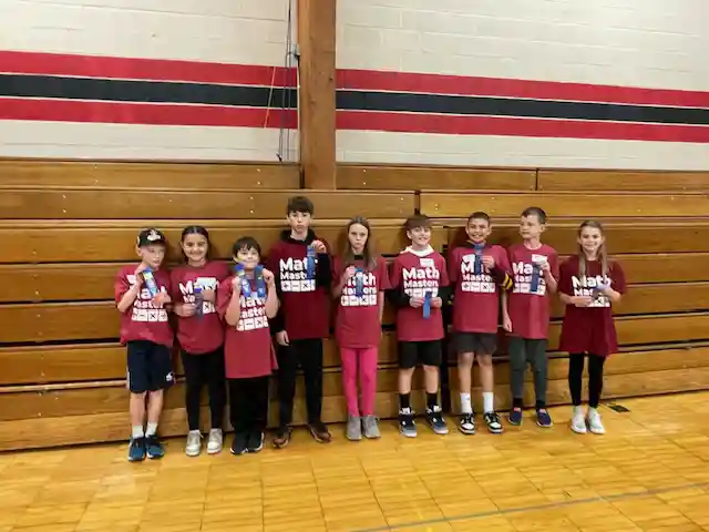 Students standing holding their medals