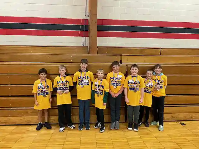 Students standing holding their medals