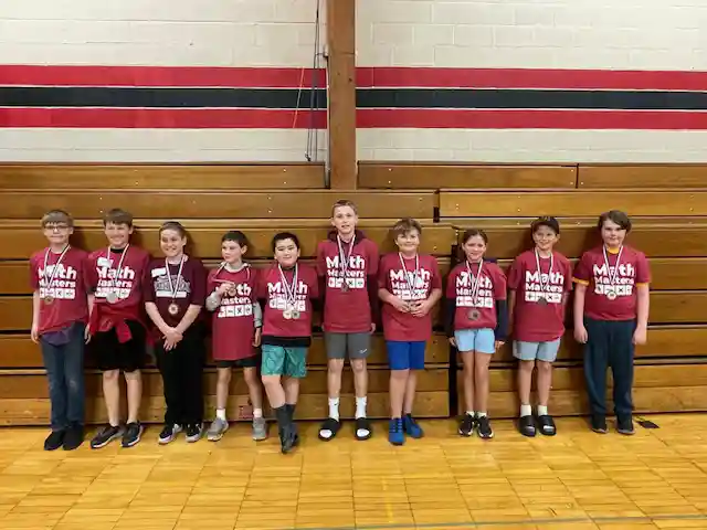 Students standing holding their medals