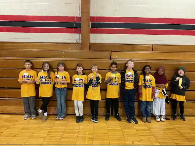 Students standing holding their medals
