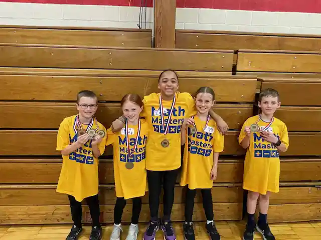 Students standing holding their medals