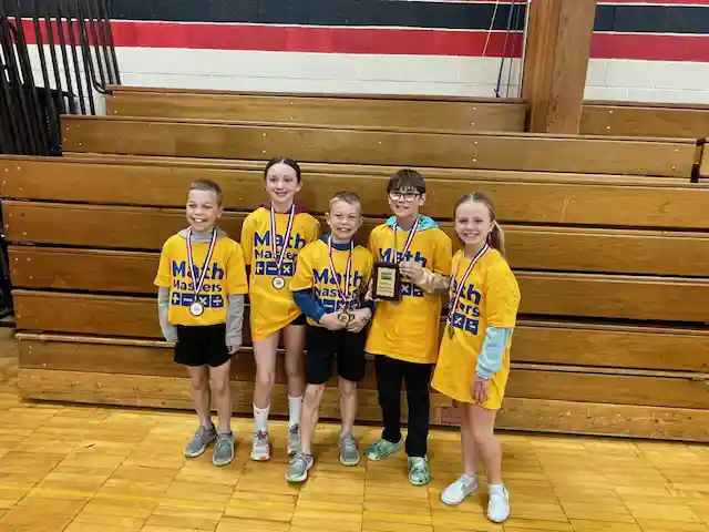 Students standing holding their medals