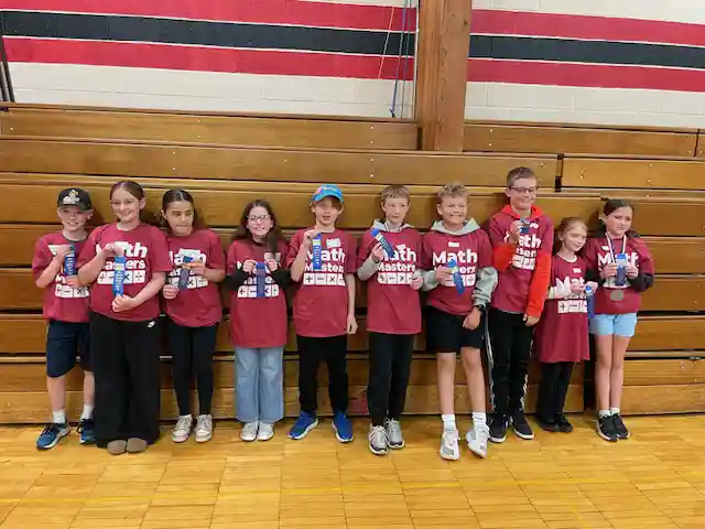Students standing holding their medals
