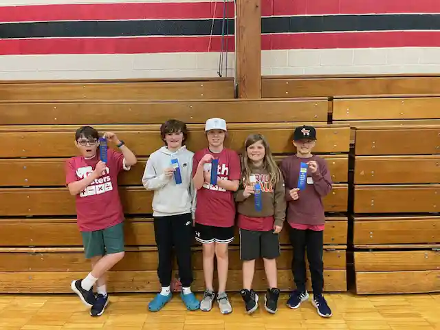 Students standing holding their medals