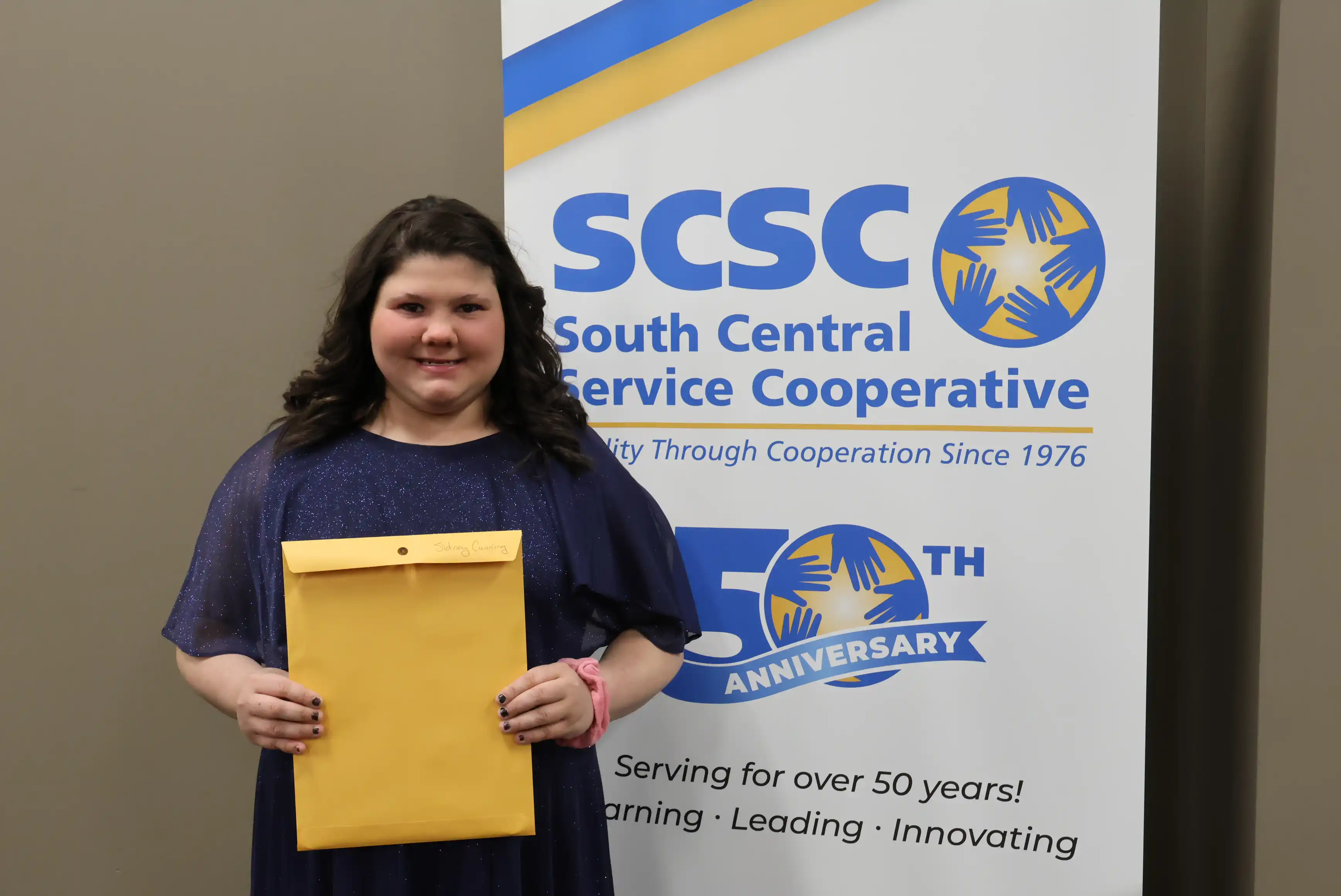 SCSC Writing Student Contestant standing with their award certificate