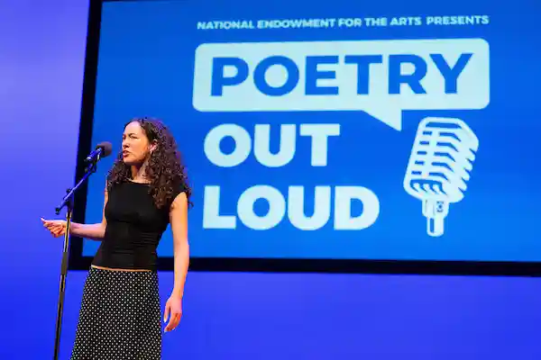 Sofia Skuza Rivera on stage reciting her poem 