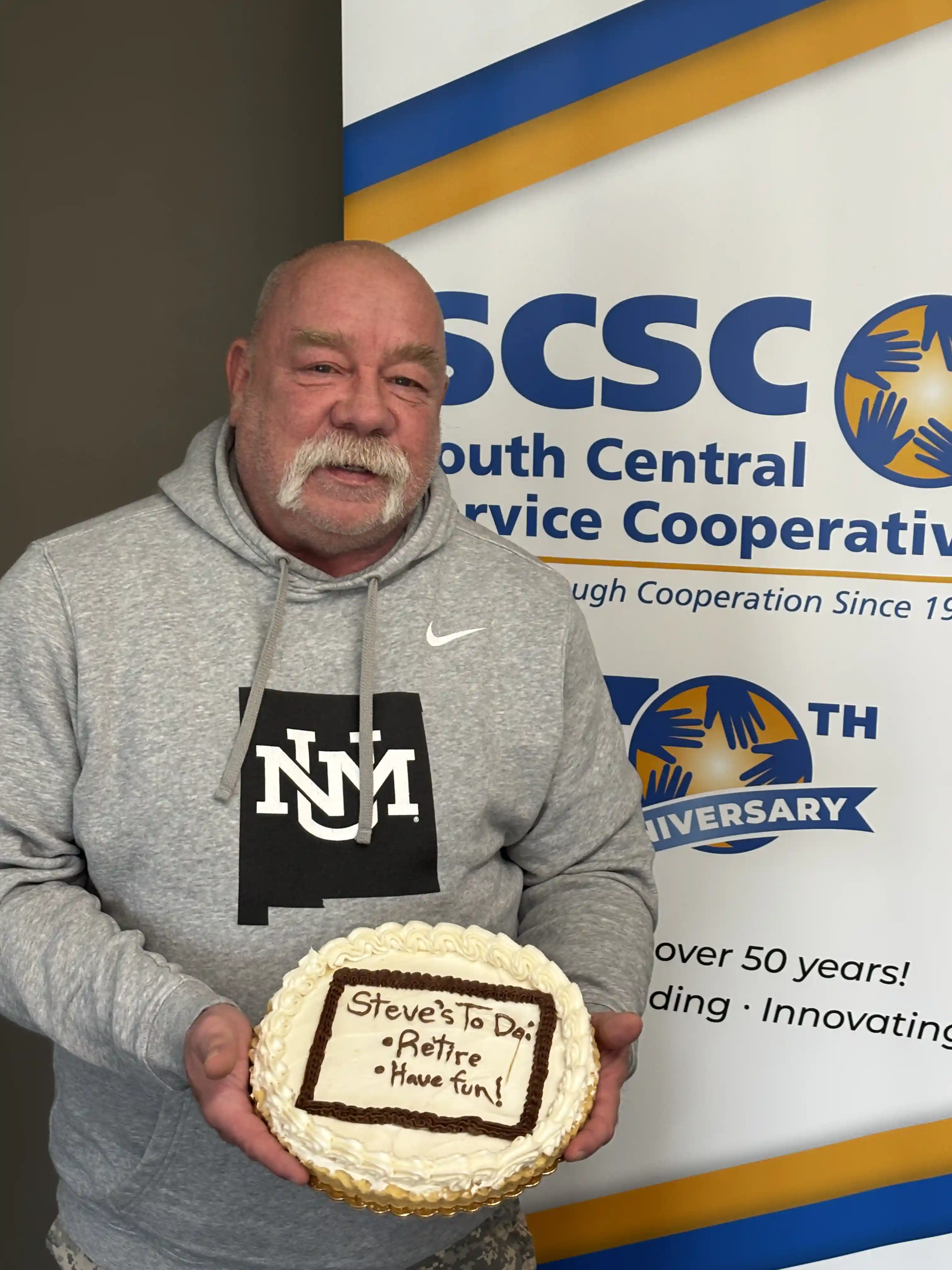 Educator Steve Schlager holding his retirement cake