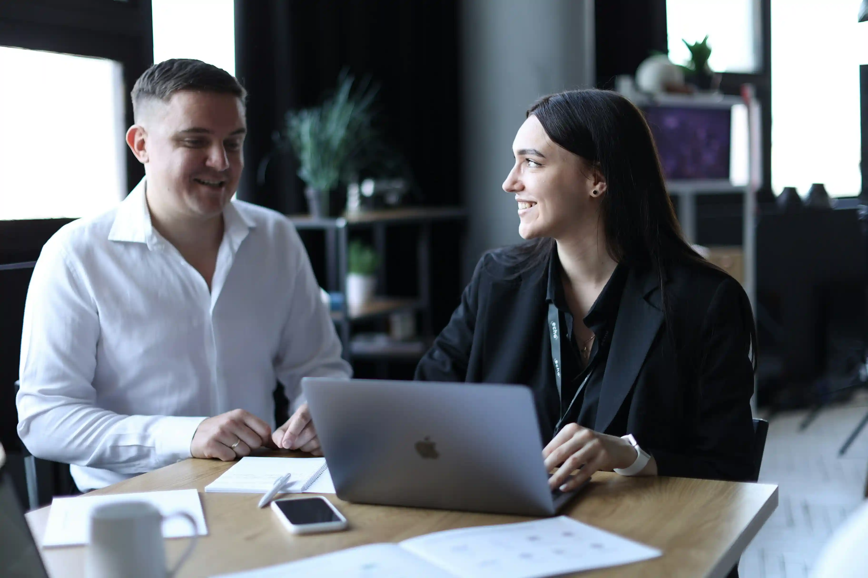 2 people sitting at a table working together
