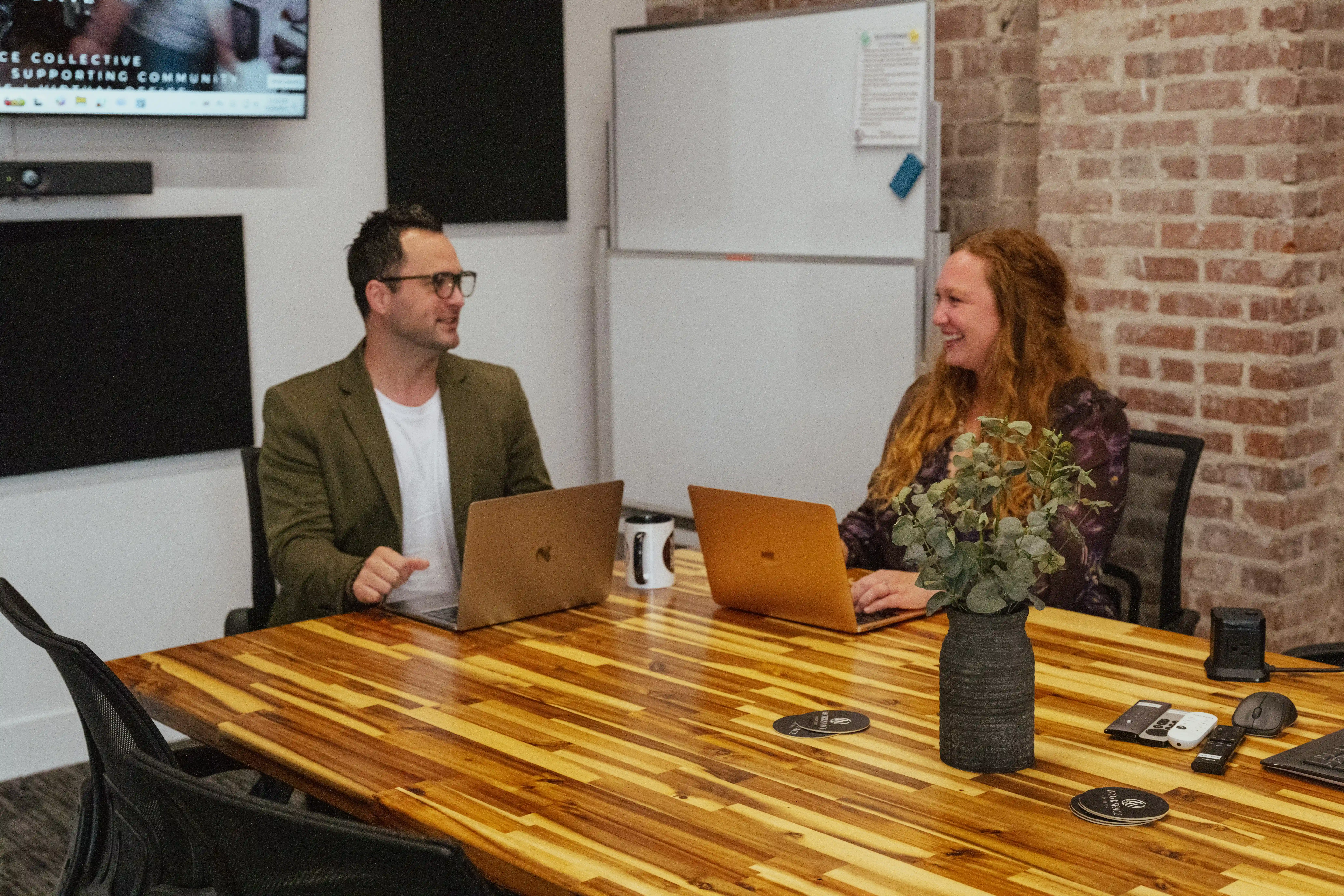 2 people sitting at a table working together