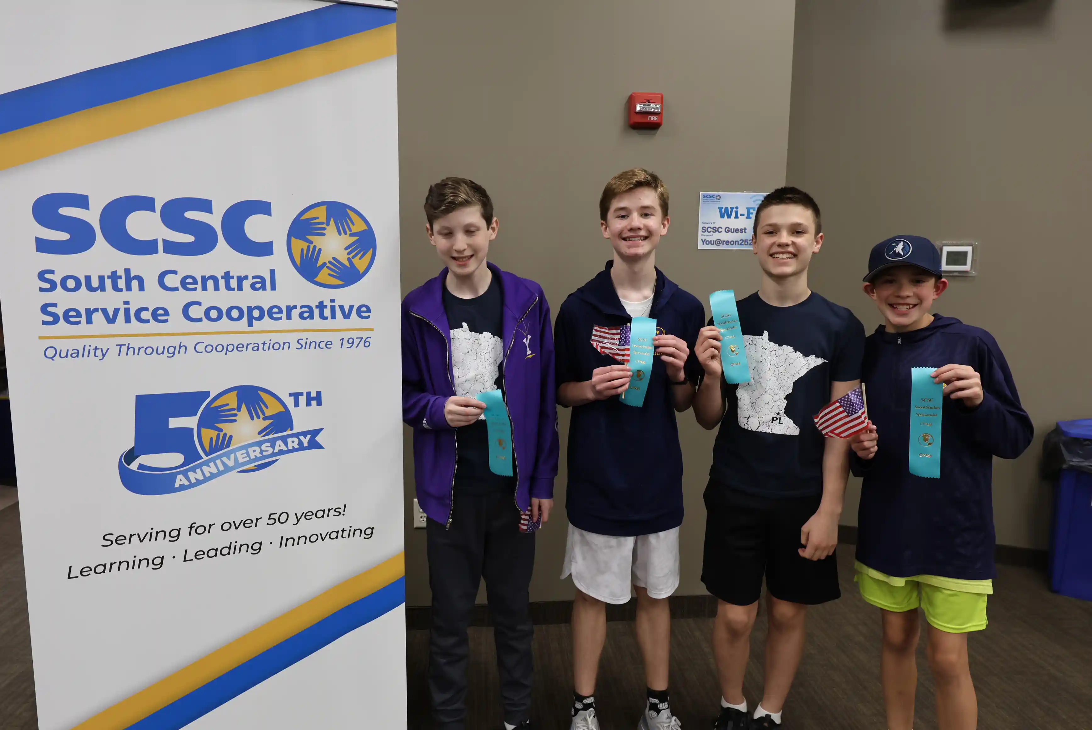 Team of students posing for a picture and holding their ribbons