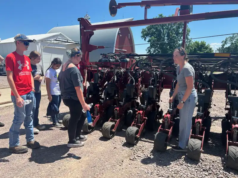students looking at a field planter