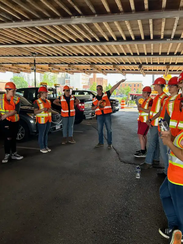 students under a bridge learning from a MNDOT worker