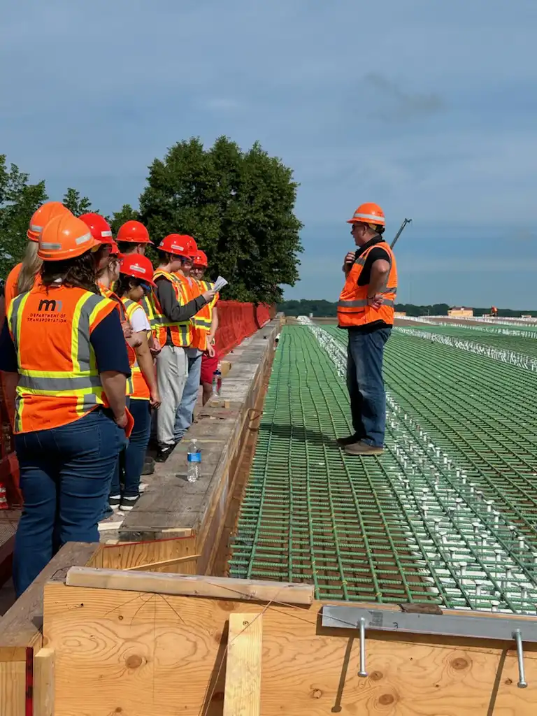 students on top of a bridge learning from a MNDOT worker