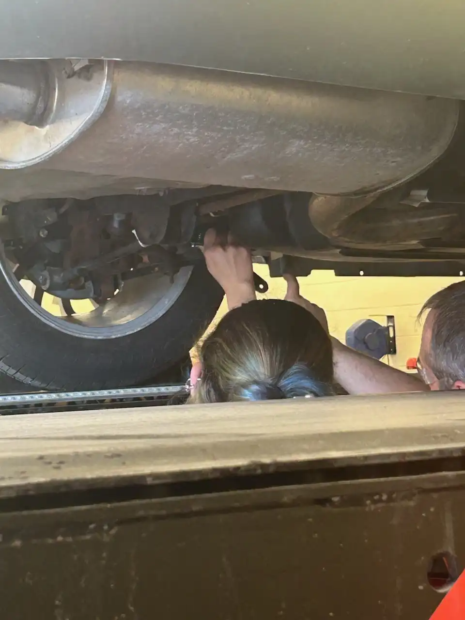 Student working under a car