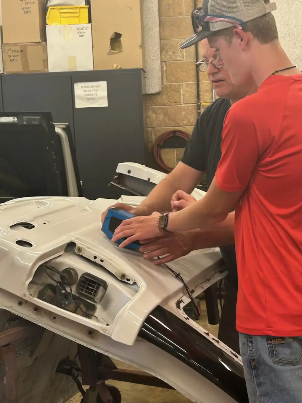 student and instructor working on an engine