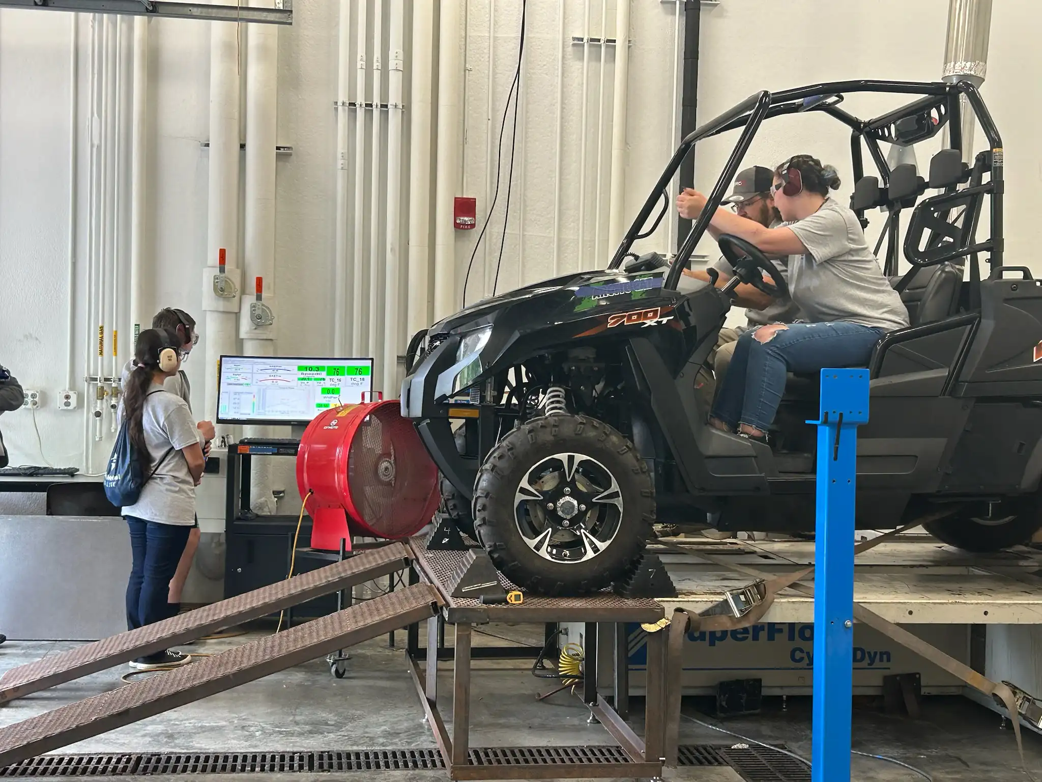 2 students on top of an UTV