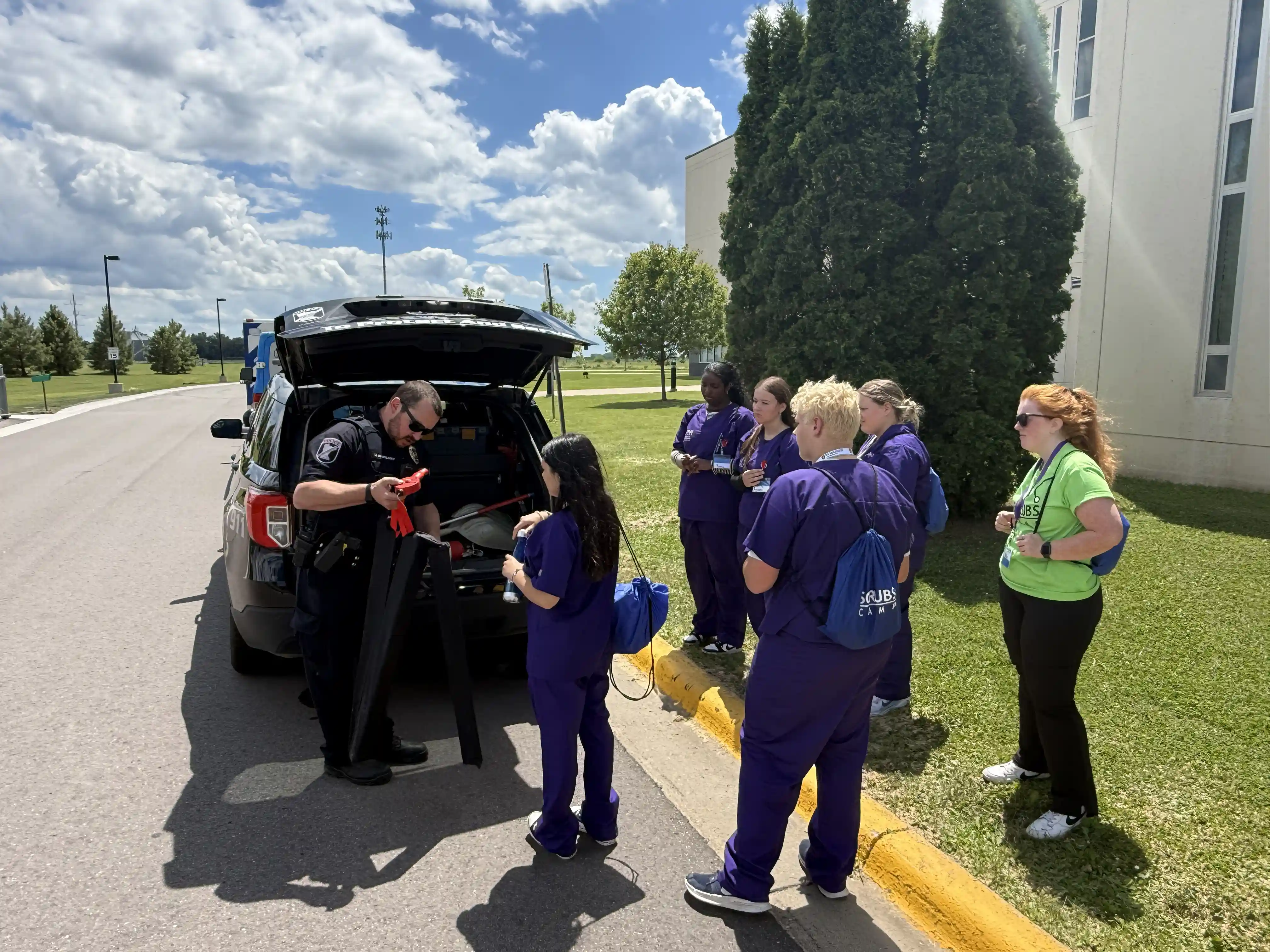 Students getting medical gear out of a vehicle