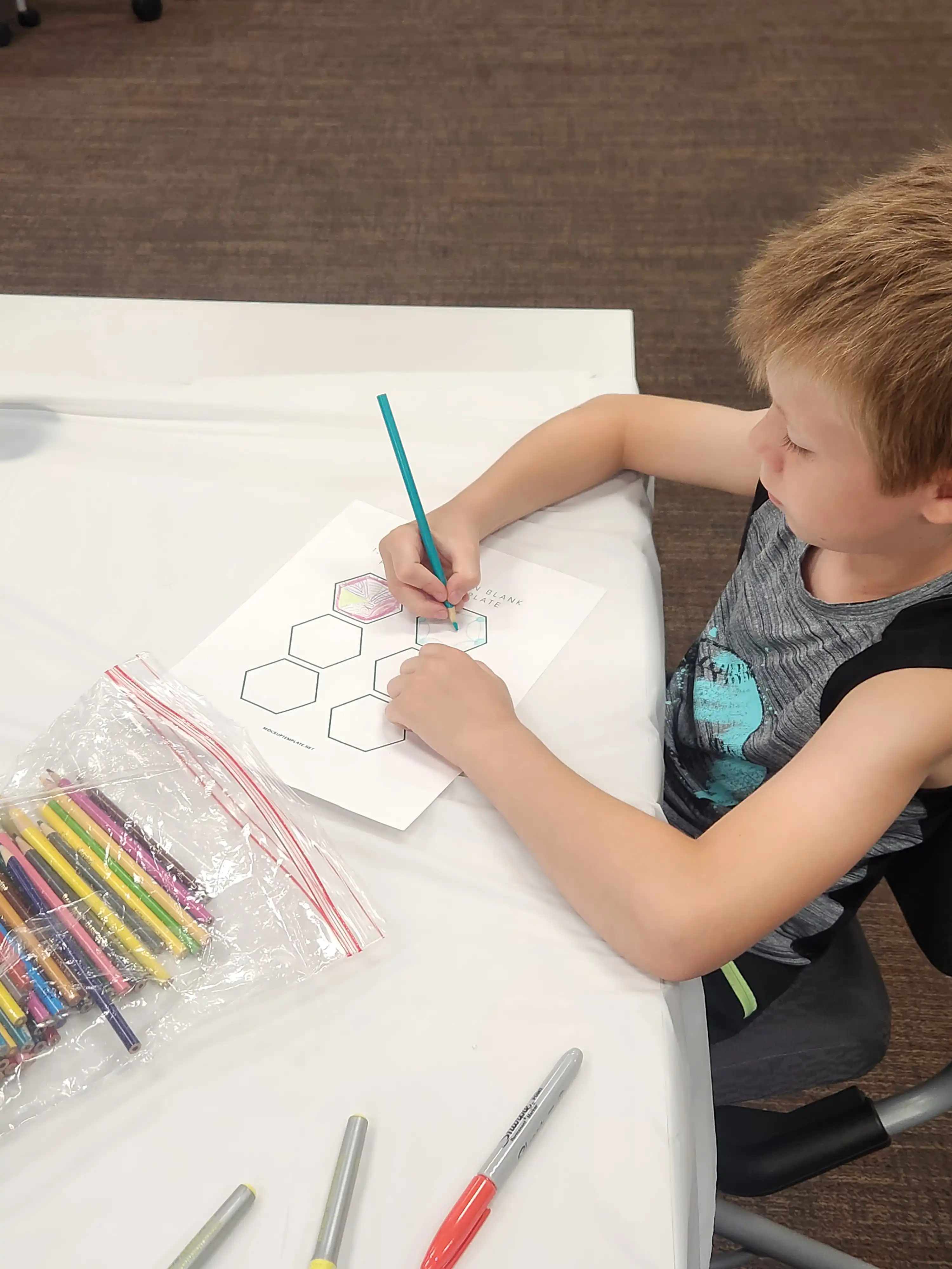 Student sitting at a table drawing