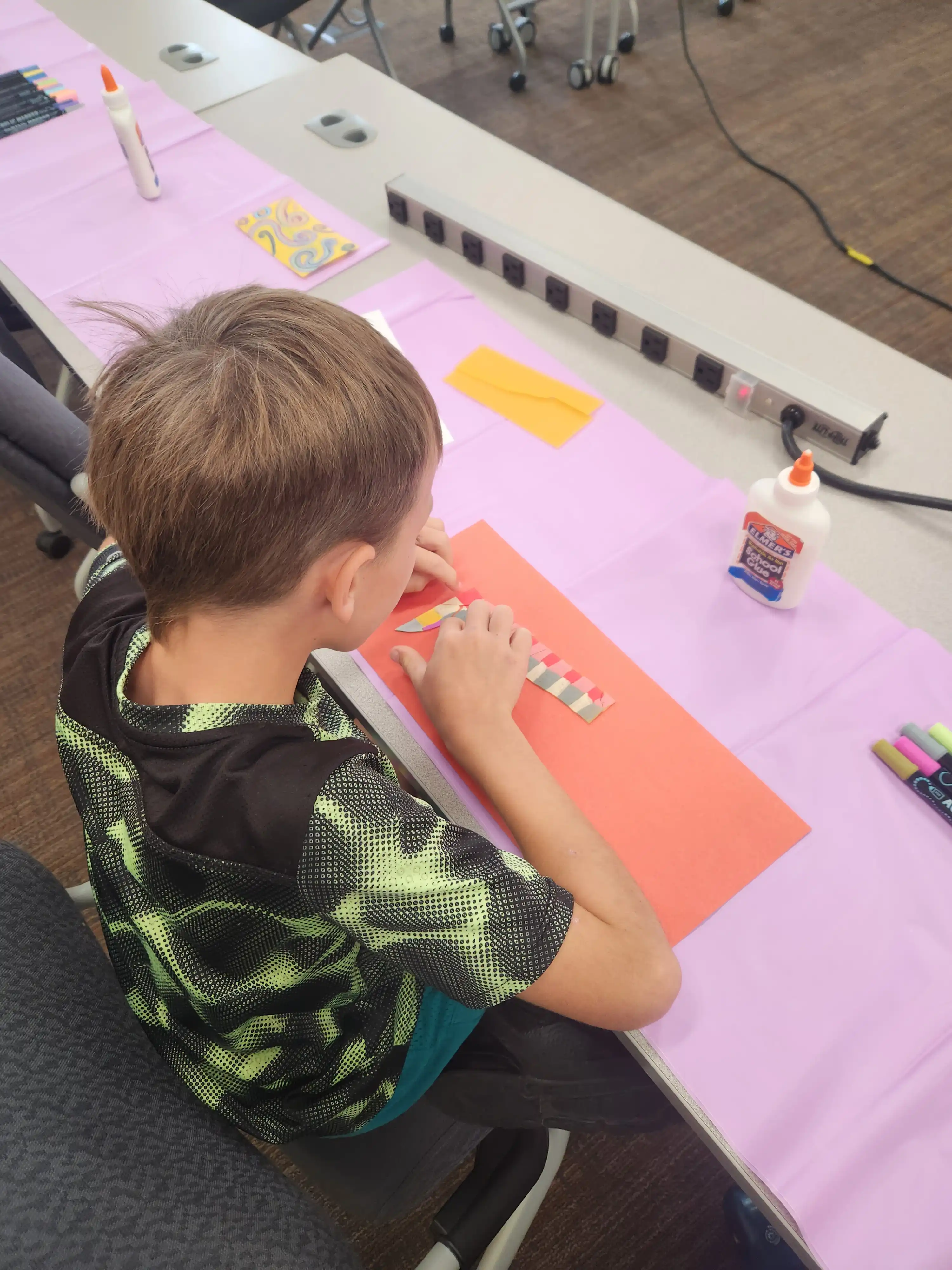 Student sitting at a table creating artwork