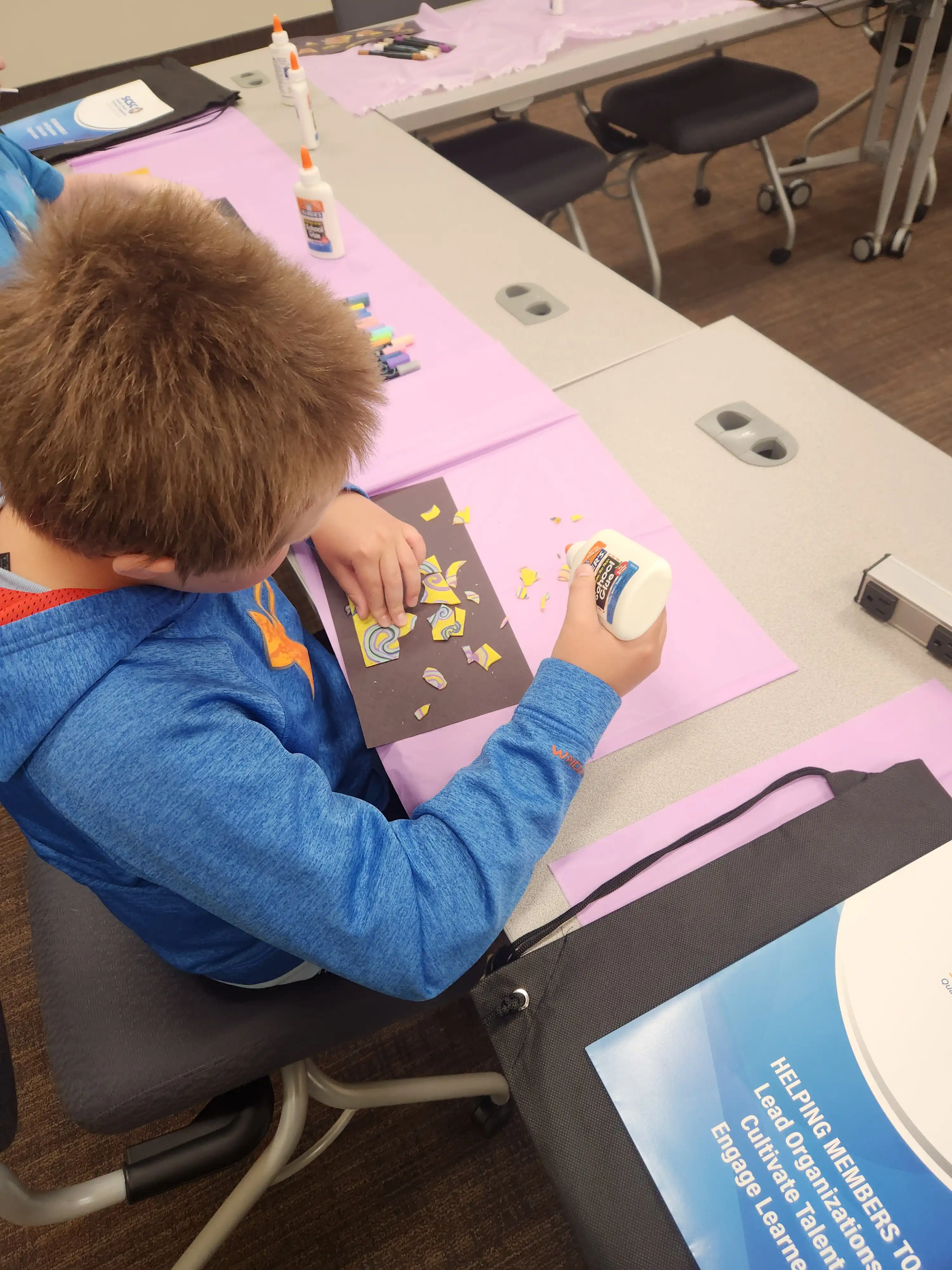 Student sitting at a table creating artwork