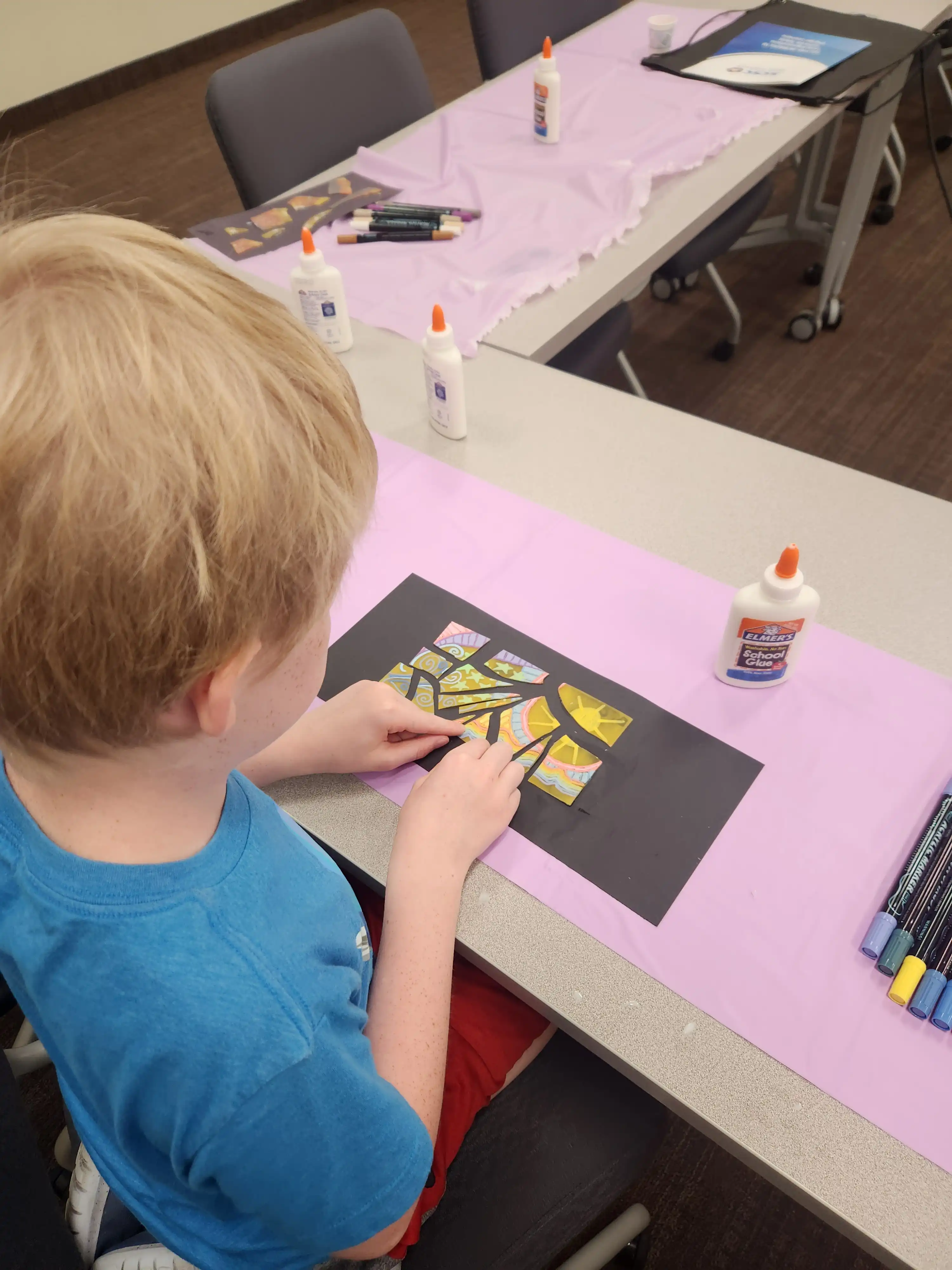 Student sitting at a table creating artwork