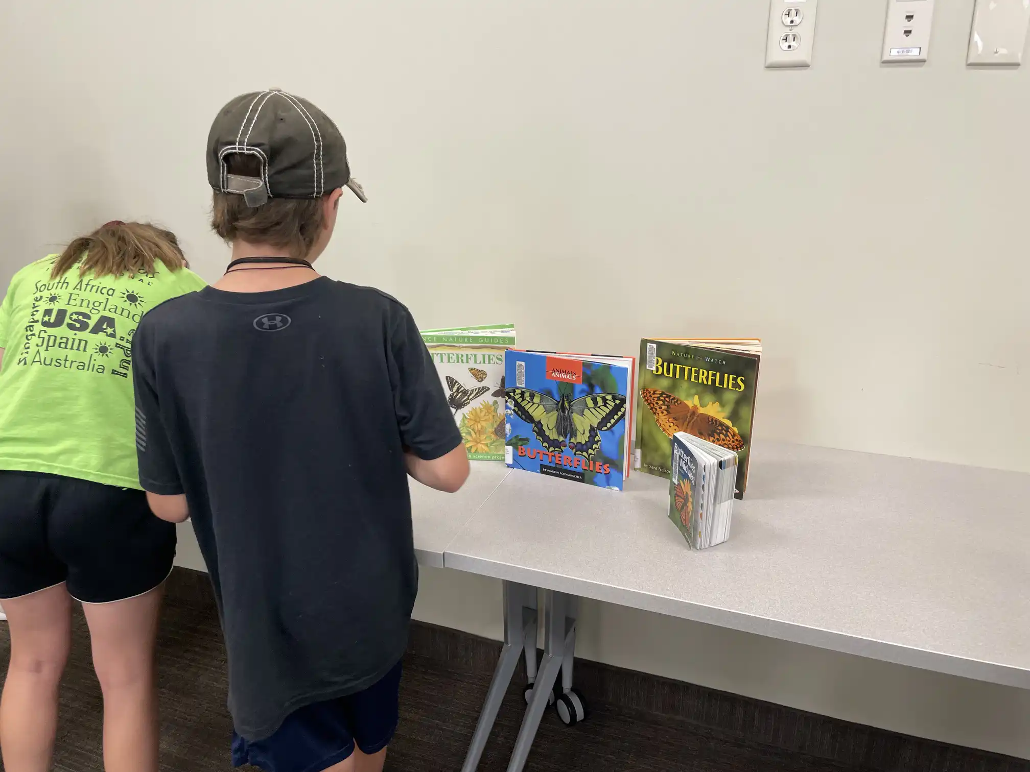 students look at artwork on a table