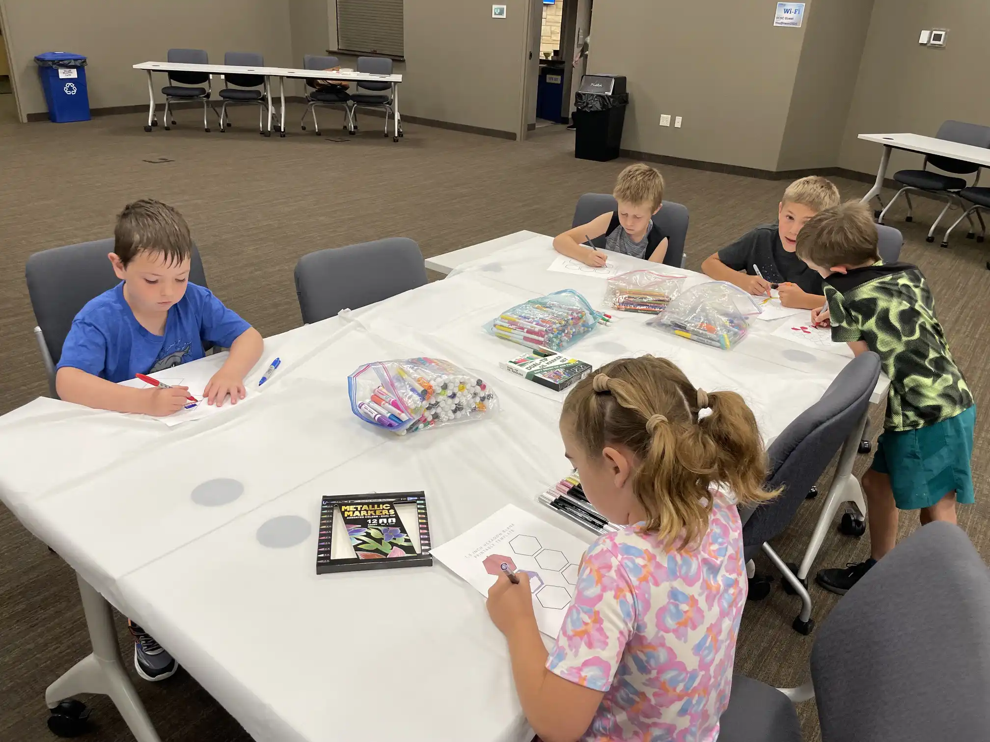 students sitting around a table working on their artwork