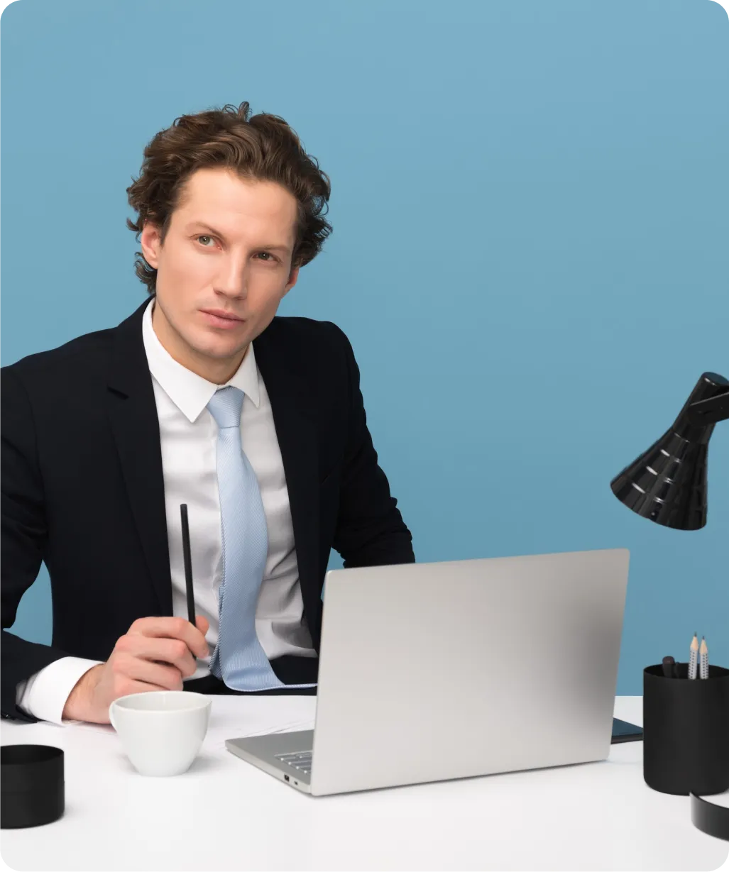a person sitting at a table with a laptop and a cup