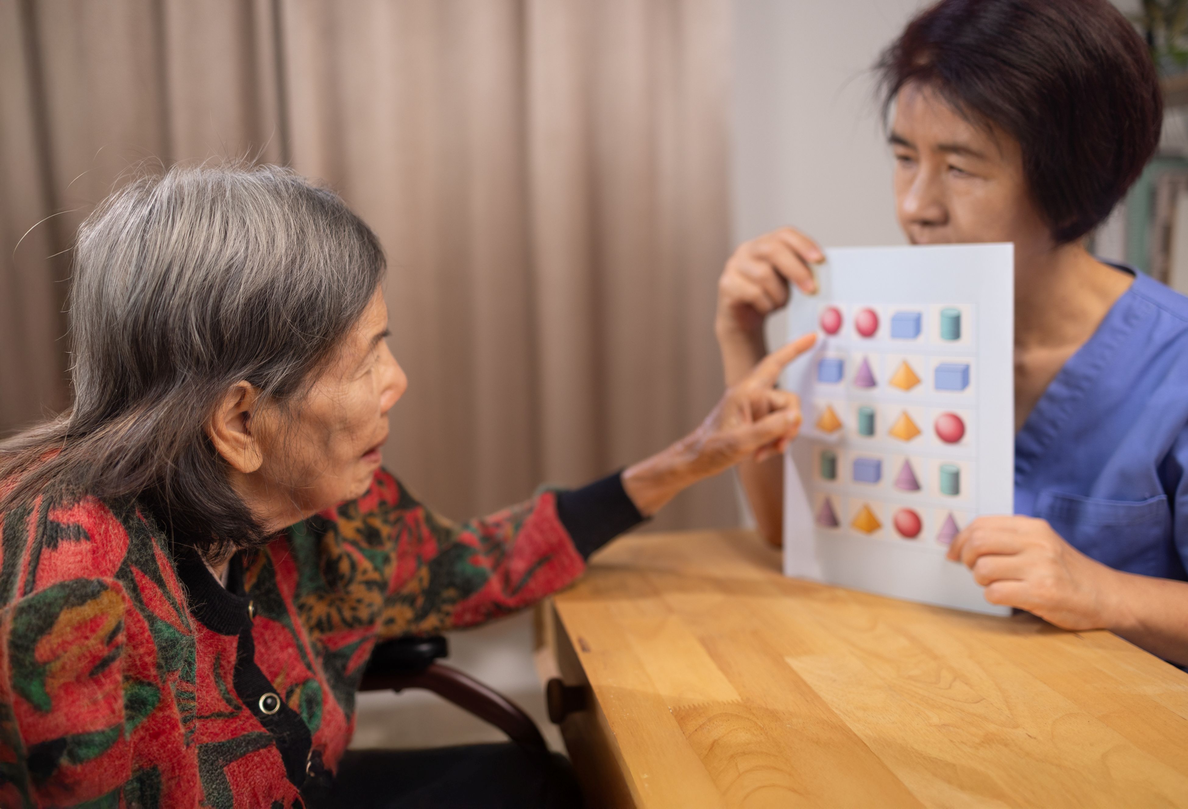 Asian Elderly Woman with Dementia Practicing match pictures.