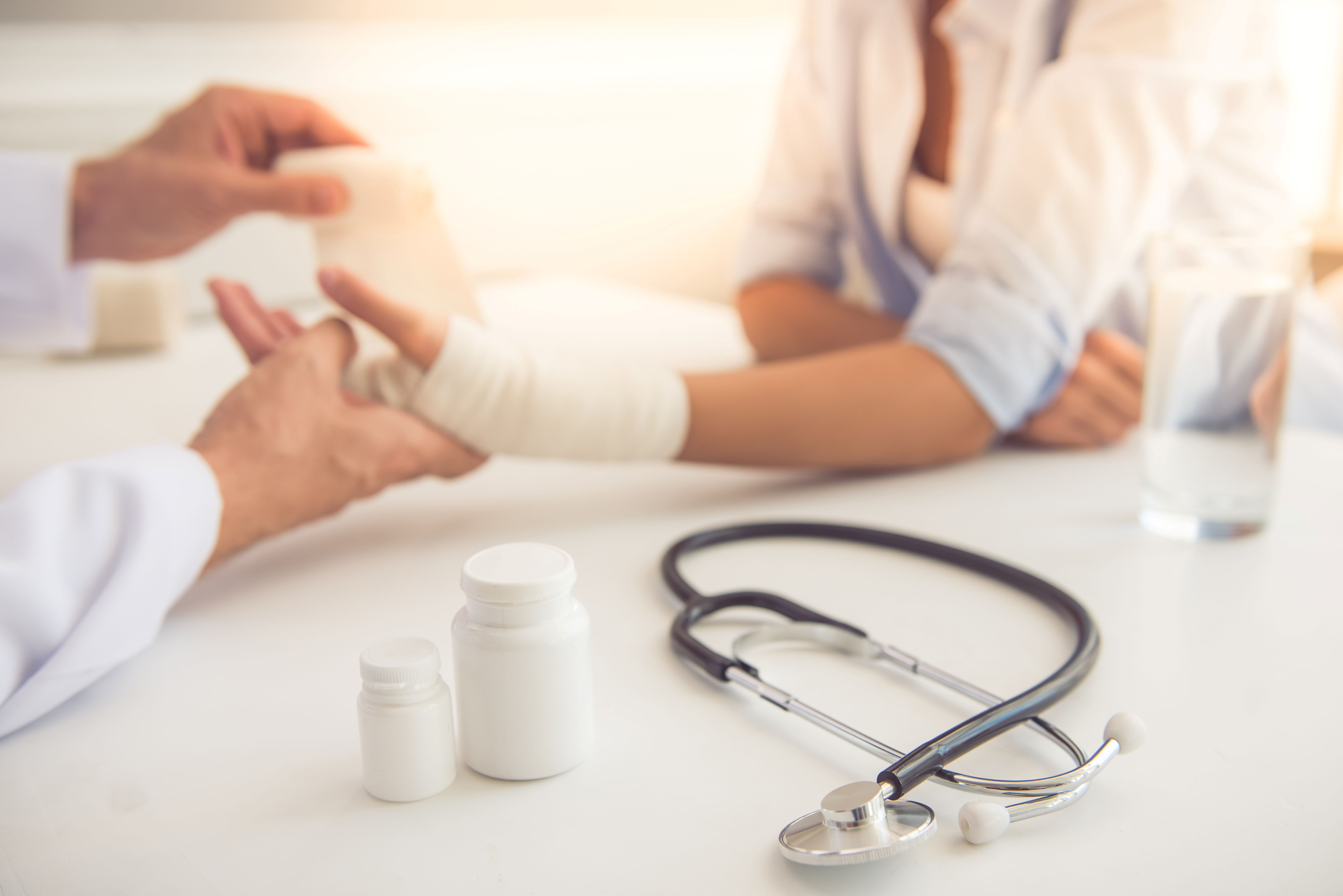 healthcare professional dressing a hand wound of a patient