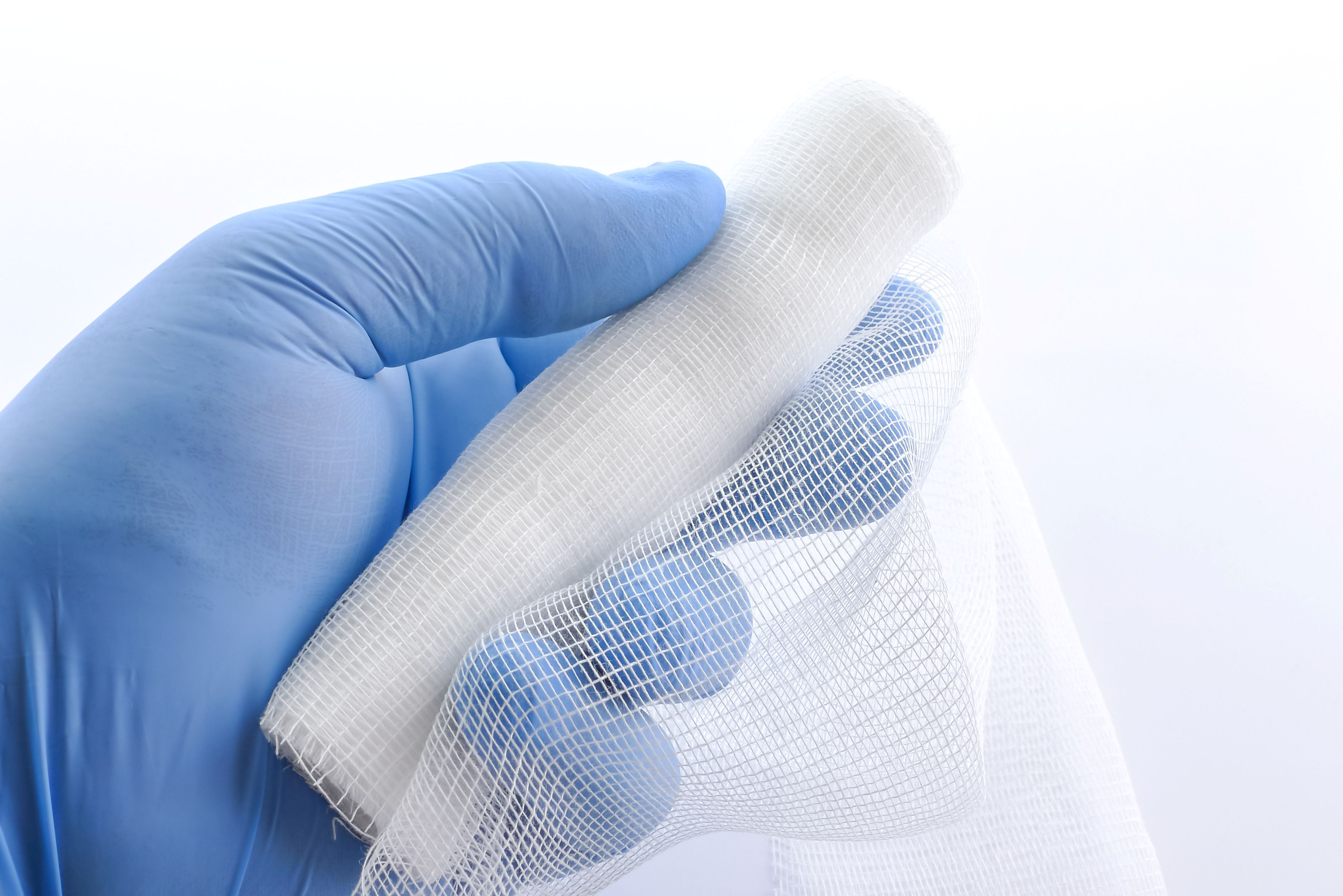 gloved and holding a sterile bandage