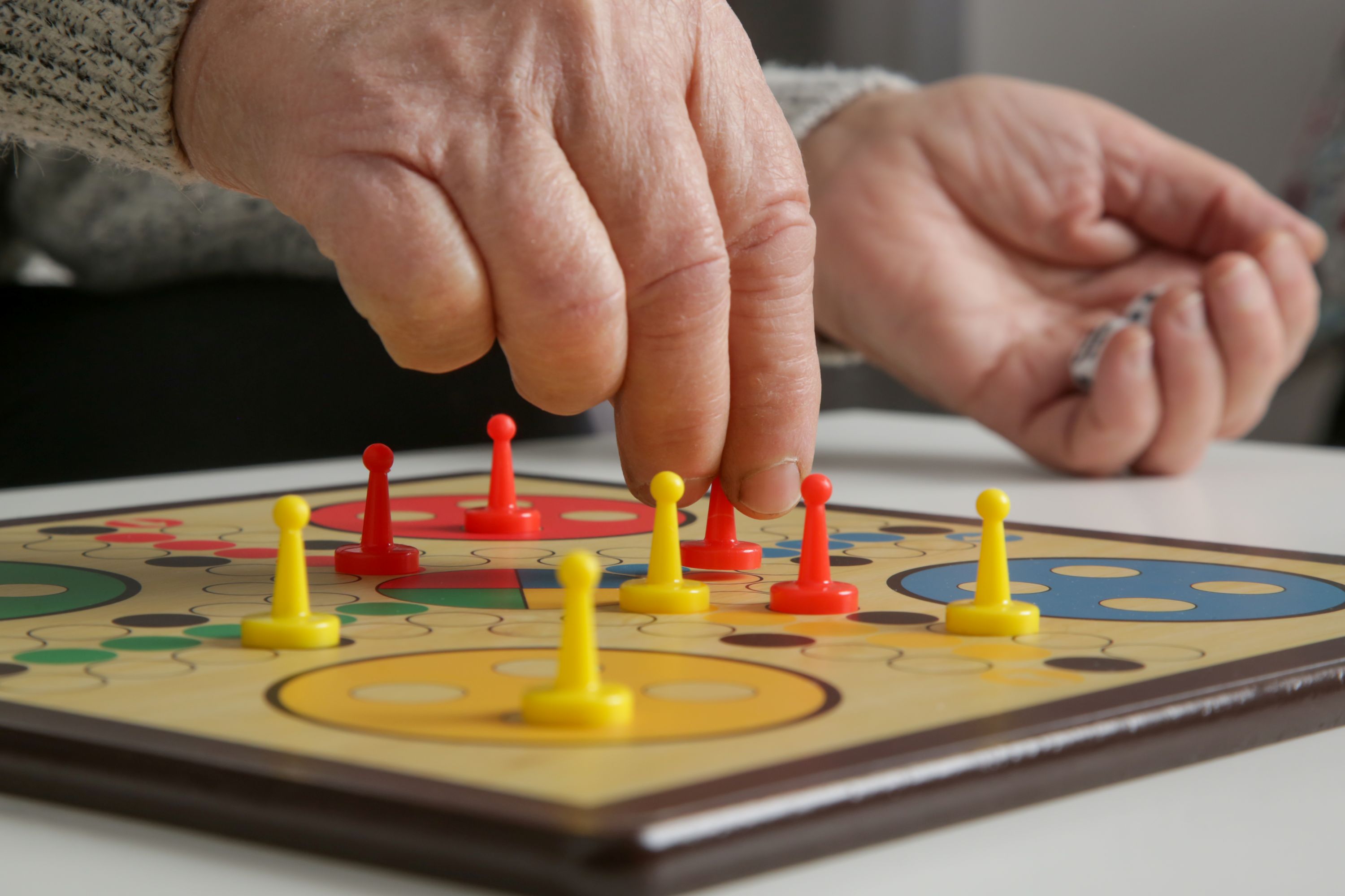 Senior woman playing board game with granddaughter or care giver. Preventing Alzheimer’s disease and dementia—or slowing its progress through leisure time and active social lives.