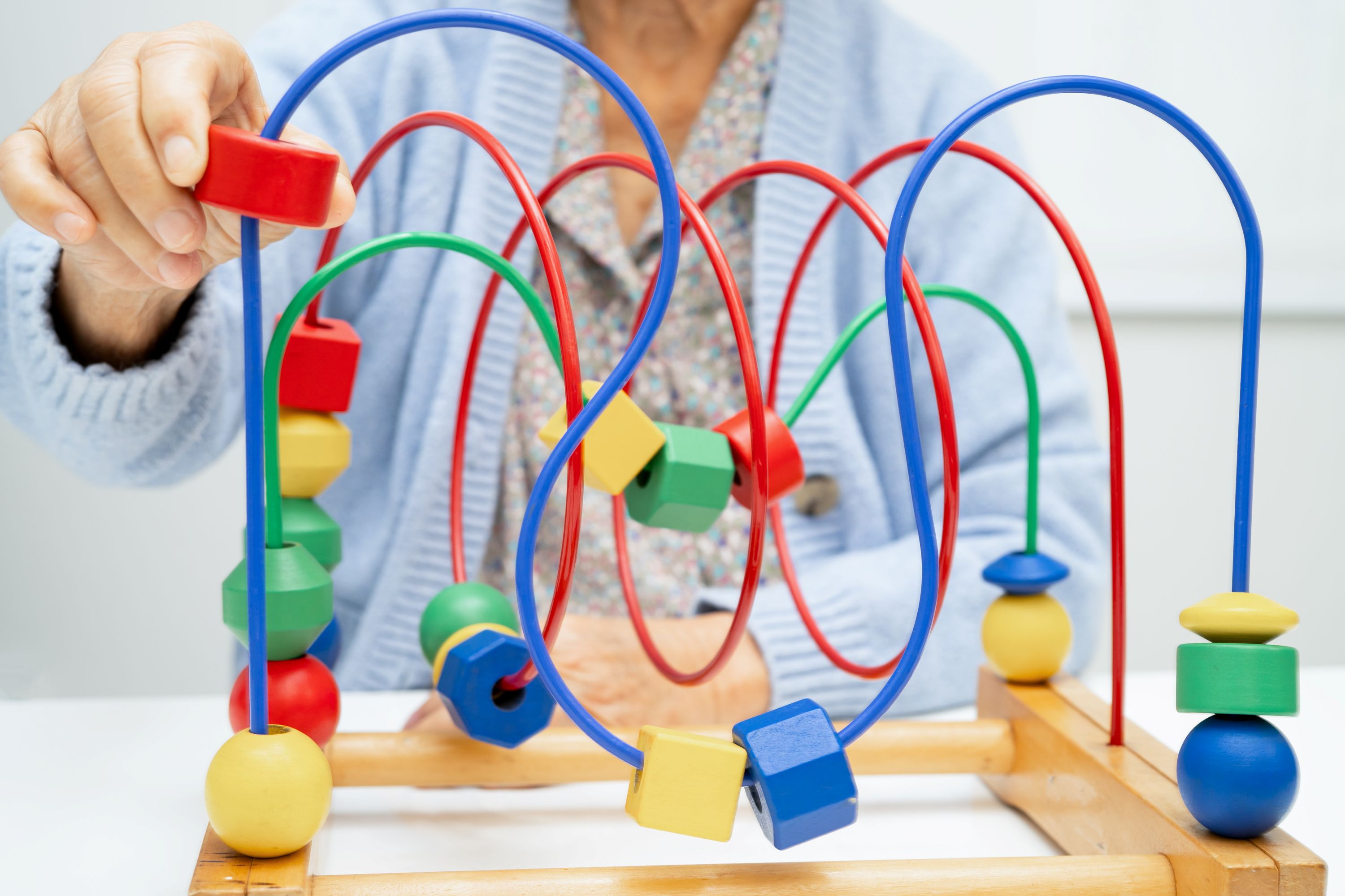 Elderly woman playing enhancing skill board game.