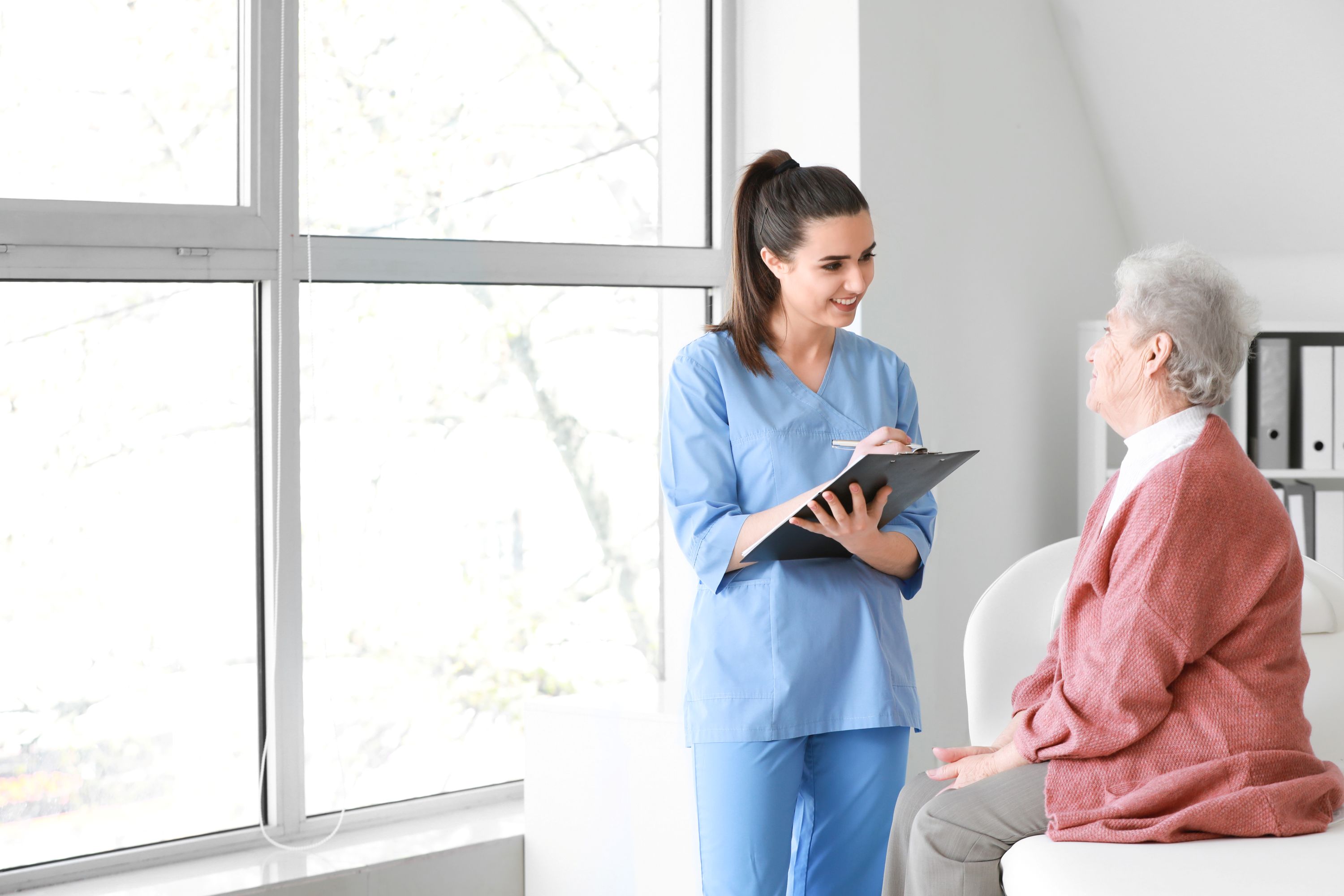 Medical worker examining senior woman in home