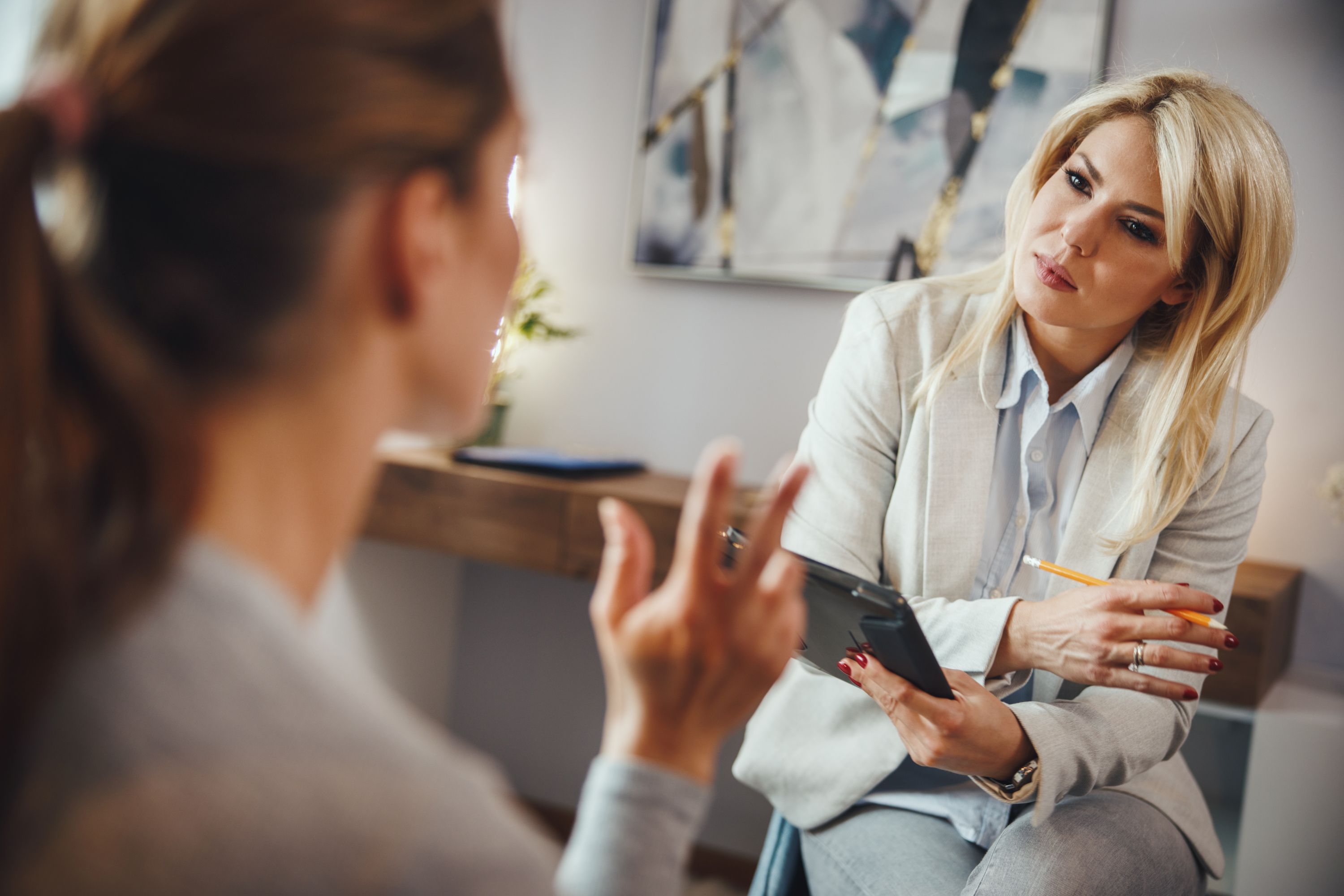 Medical professional listening intently to client and taking notes