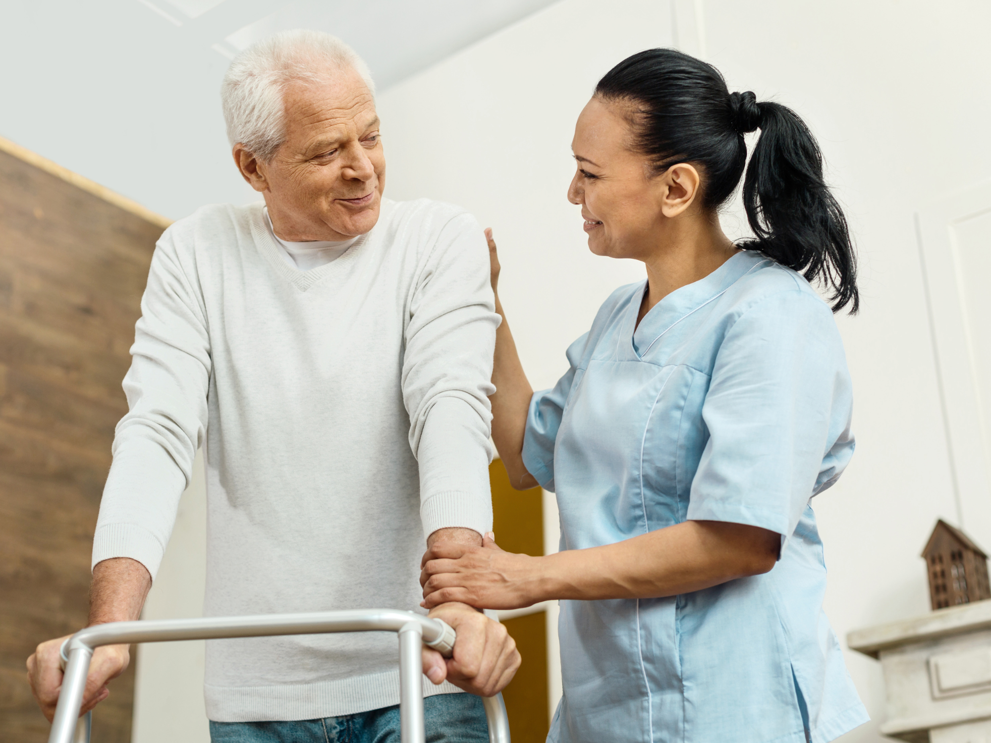 Cheerful friendly home healthcare professional helping the elderly man