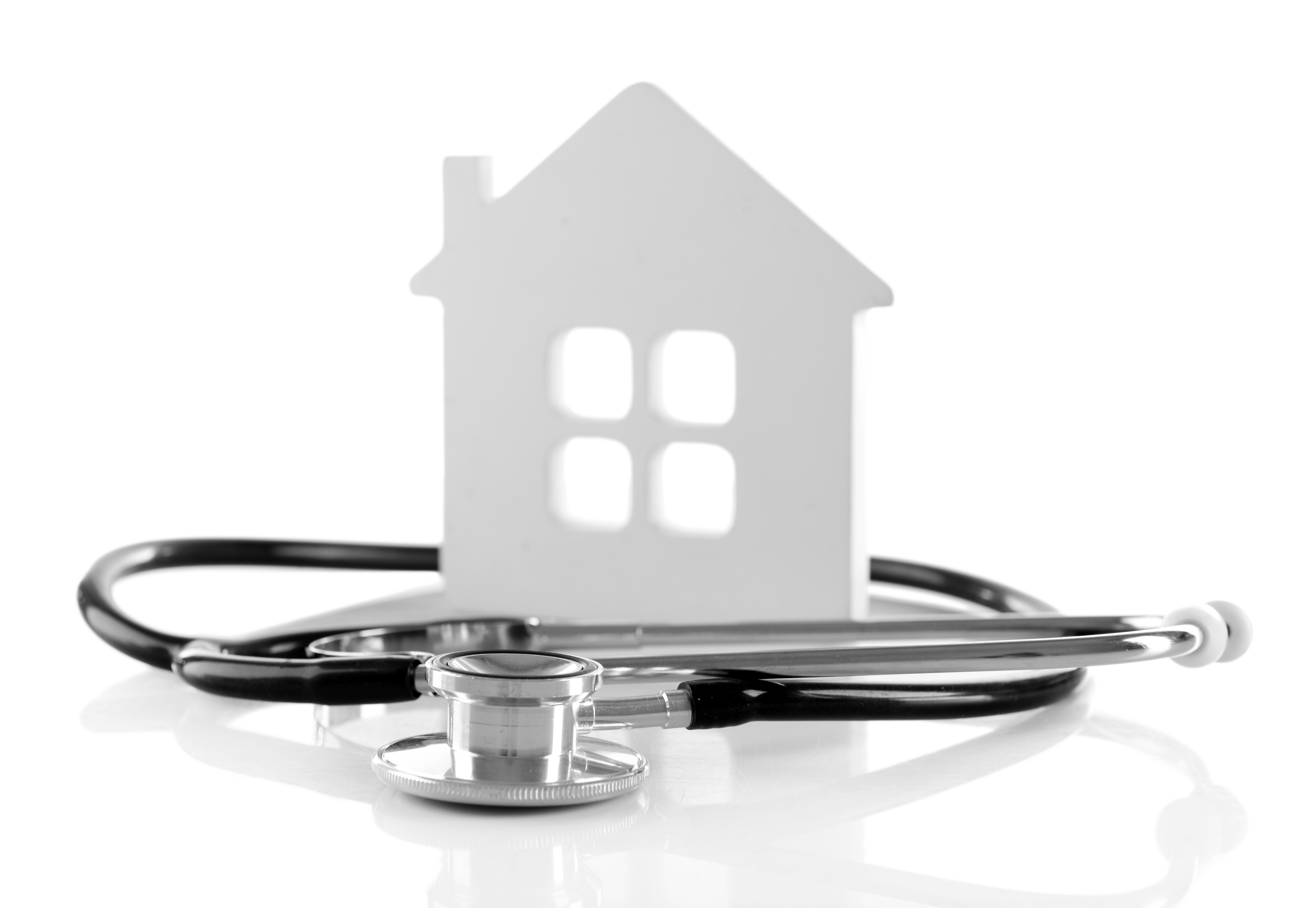 Concept of family medicine - white mini house and stethoscope isolated on white background